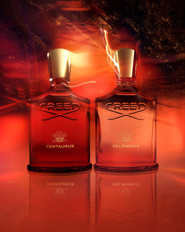 Frascos de perfume Creed Centaurus y Creed Delphinus en un fondo rojo con brillos