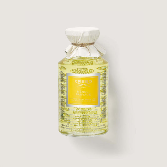 Frasco de perfume Creed Neroli Sauvage de 100 ml en un fondo fondo beige claro.